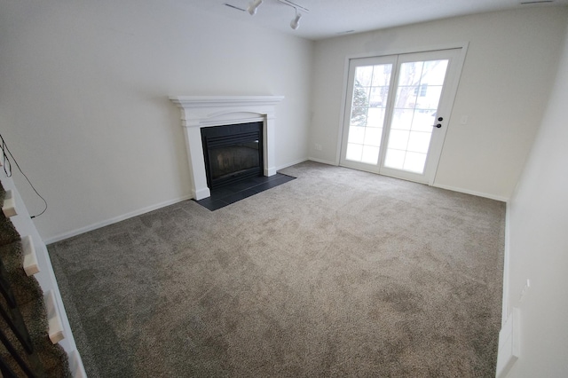 unfurnished living room with rail lighting and dark carpet