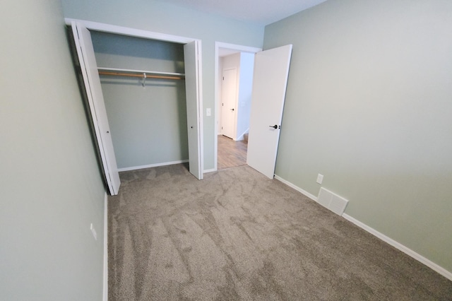 unfurnished bedroom with a closet and light carpet