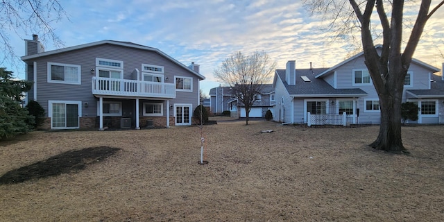 rear view of property featuring a balcony and cooling unit