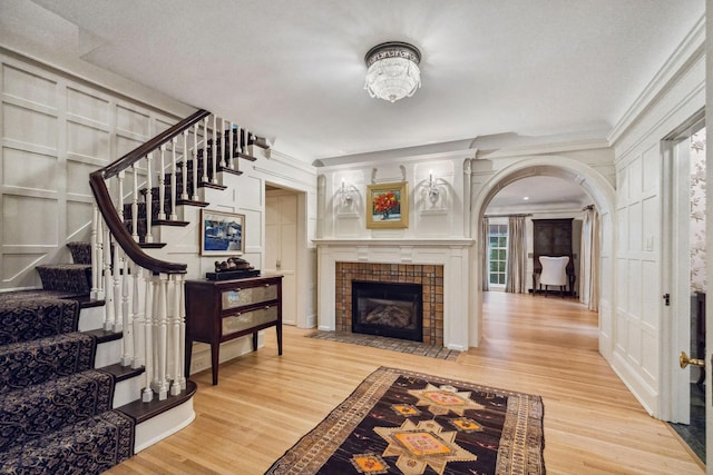 5231 Clinton Ave, Minneapolis, MN 55419 - foyer entrance featuring a fireplace, a decorative wall, arched walkways, stairs, and wood finished floors
