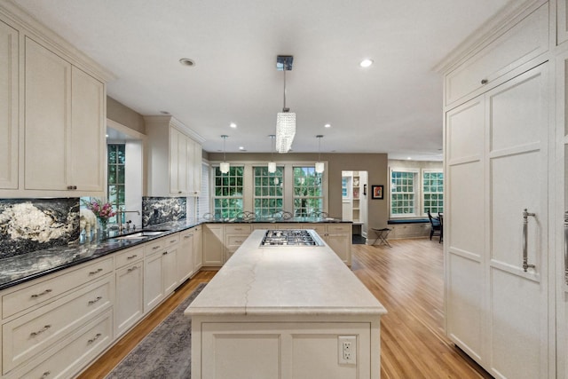 5231 Clinton Ave, Minneapolis, MN 55419 - kitchen featuring a peninsula, stainless steel gas cooktop, a center island, a sink, and light wood finished floors