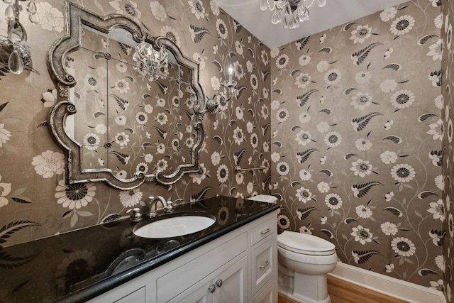 5231 Clinton Ave, Minneapolis, MN 55419 - half bathroom featuring vanity, wood finished floors, toilet, and wallpapered walls