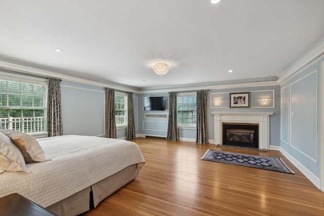 5231 Clinton Ave, Minneapolis, MN 55419 - bedroom featuring crown molding, a decorative wall, wood finished floors, recessed lighting, and a fireplace with flush hearth