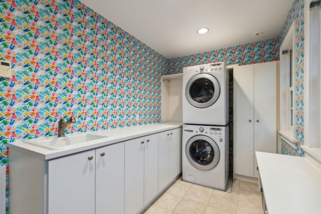 5231 Clinton Ave, Minneapolis, MN 55419 - laundry area featuring cabinet space, a sink, stacked washer and clothes dryer, wallpapered walls, and light tile patterned flooring