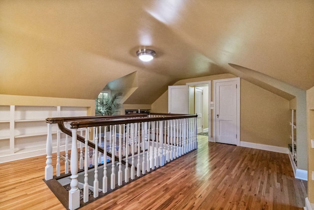 5231 Clinton Ave, Minneapolis, MN 55419 - additional living space featuring built in shelves, baseboards, vaulted ceiling, and wood finished floors