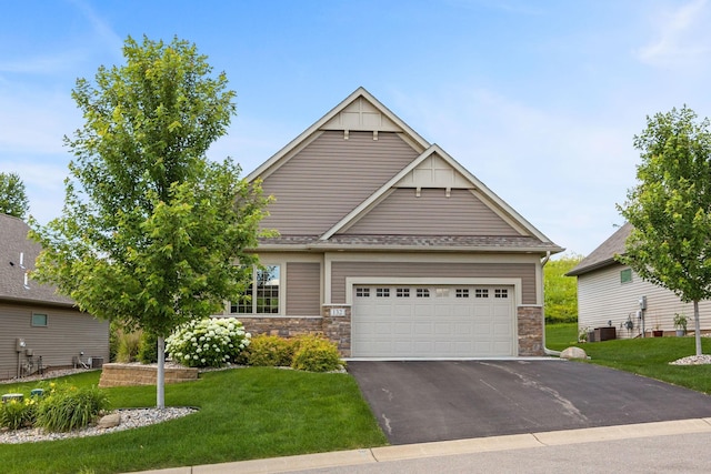 craftsman house featuring a garage, central AC, and a front yard