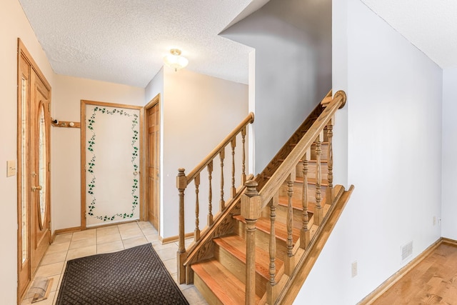 entrance foyer featuring light tile patterned floors and a textured ceiling