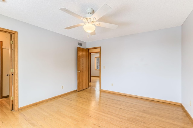 empty room with ceiling fan, a textured ceiling, and light hardwood / wood-style floors