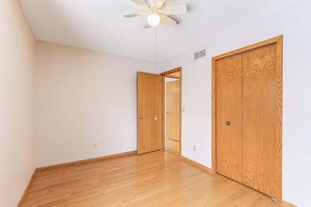 unfurnished bedroom featuring a closet, a textured ceiling, ceiling fan, and light hardwood / wood-style flooring