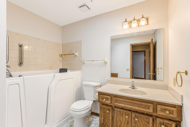 bathroom featuring vanity, a bathing tub, and toilet