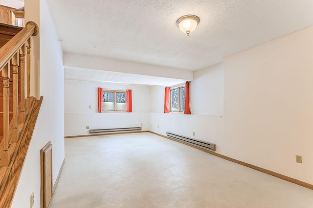 spare room with baseboard heating, concrete flooring, and a textured ceiling