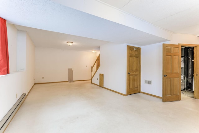 basement with a baseboard heating unit and light colored carpet