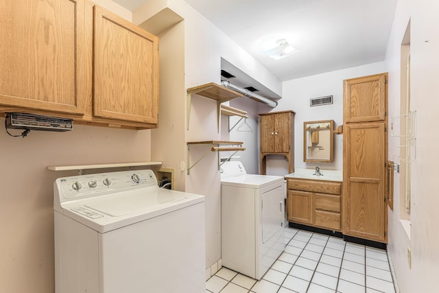 laundry room with cabinets, light tile patterned flooring, washer and dryer, and sink