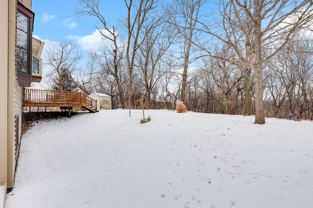 yard layered in snow with a deck