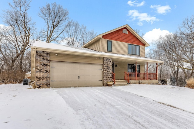 view of front of home featuring a garage, a porch, and central air condition unit