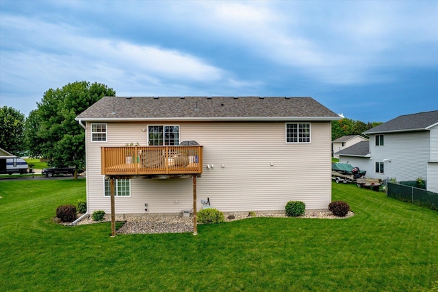 back of property featuring a wooden deck and a lawn