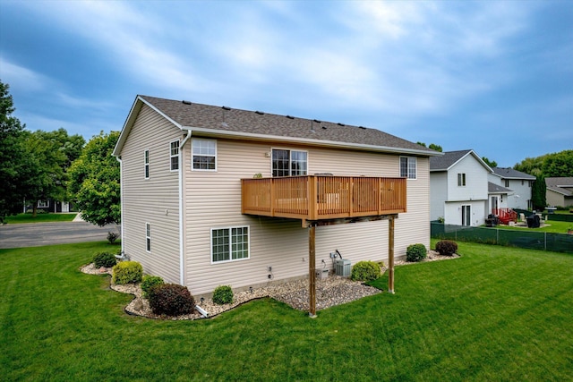 rear view of house featuring central AC unit, a lawn, and a deck