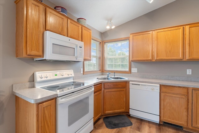 kitchen with dark hardwood / wood-style floors, lofted ceiling, sink, and white appliances