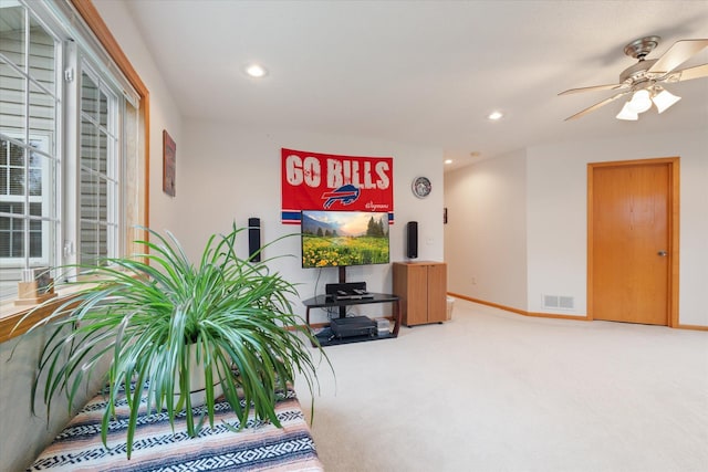 carpeted living room with ceiling fan