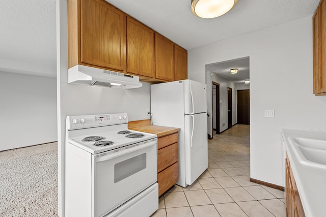 kitchen with light tile patterned floors, white appliances, and sink