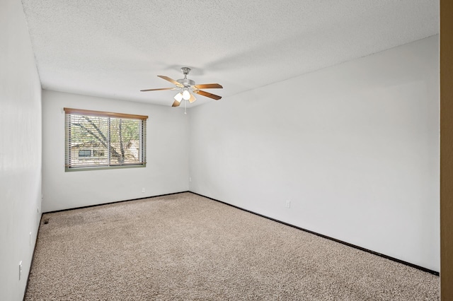 empty room with ceiling fan, light carpet, and a textured ceiling