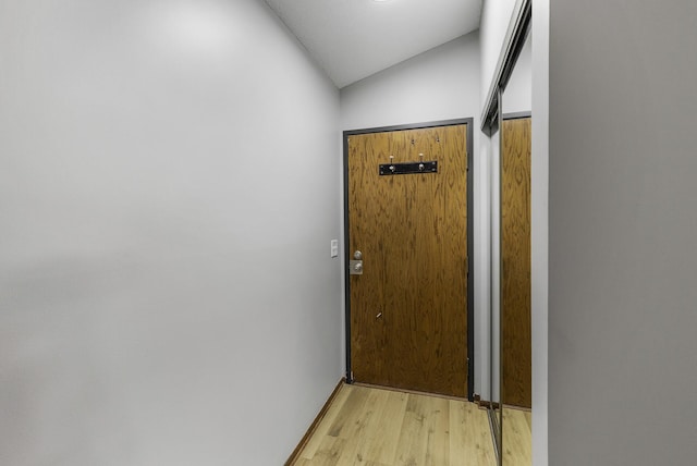 doorway to outside featuring lofted ceiling and light hardwood / wood-style flooring