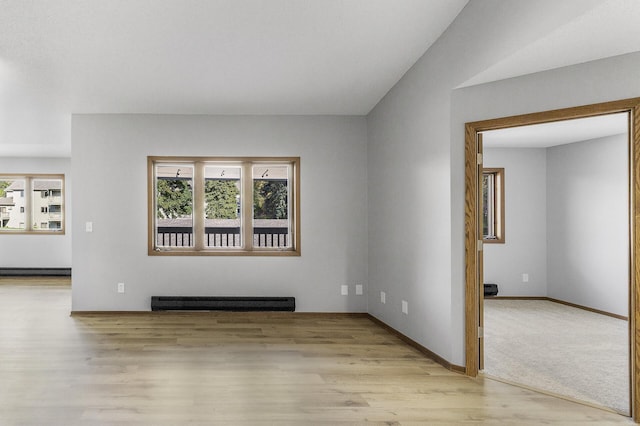 unfurnished living room featuring baseboard heating and light wood-type flooring