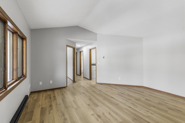 unfurnished room featuring lofted ceiling, a baseboard radiator, and light wood-type flooring