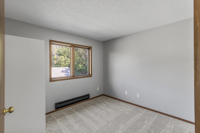 carpeted empty room featuring a textured ceiling and a baseboard heating unit