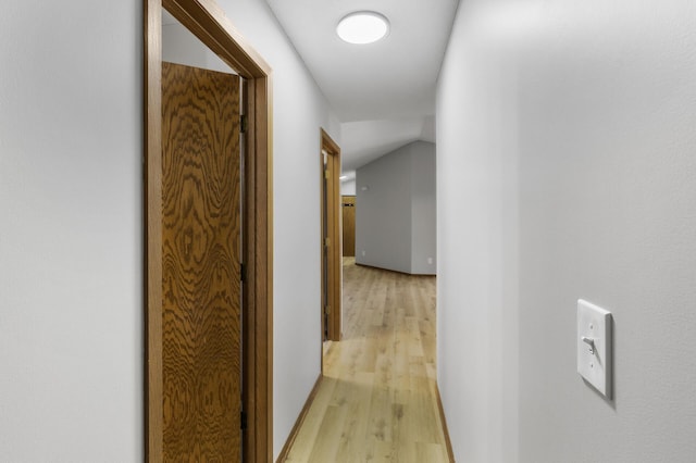 hall featuring vaulted ceiling and light hardwood / wood-style floors