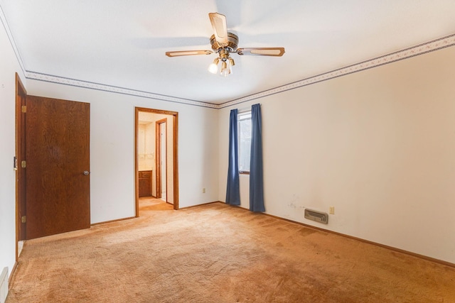 unfurnished bedroom featuring crown molding, light colored carpet, ceiling fan, and ensuite bathroom