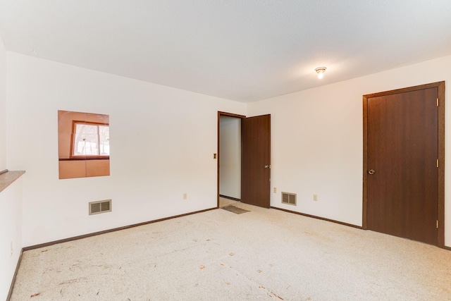 spare room featuring light colored carpet