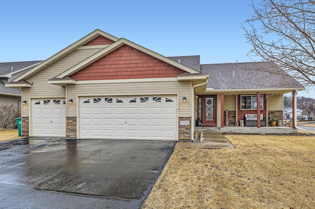 view of front of house with a garage, stone siding, driveway, and a shingled roof