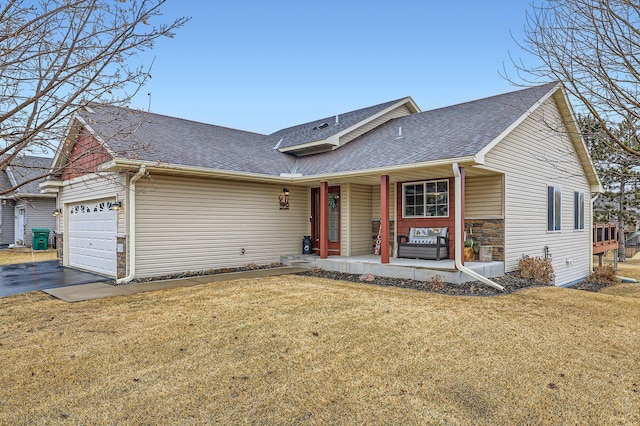 view of front of property featuring a front yard, an attached garage, and a shingled roof