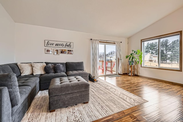 living room with baseboards, lofted ceiling, and wood finished floors