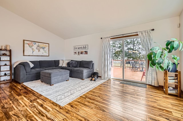 living room with wood finished floors and vaulted ceiling