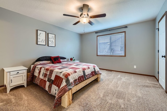 bedroom with baseboards, light carpet, a textured ceiling, and ceiling fan