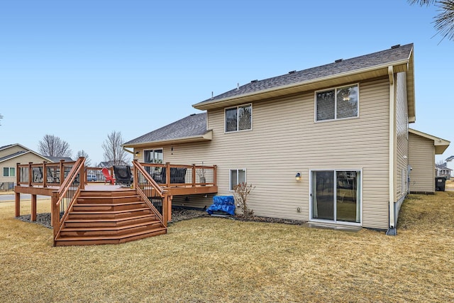 rear view of property featuring a yard, a wooden deck, and stairway