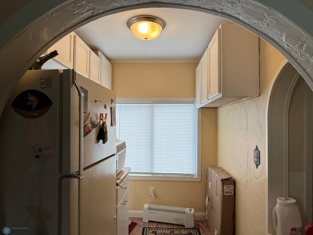 kitchen with baseboard heating and white fridge