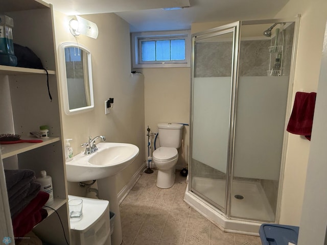 bathroom with tile patterned floors, toilet, and a shower with shower door