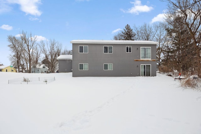 view of snow covered back of property