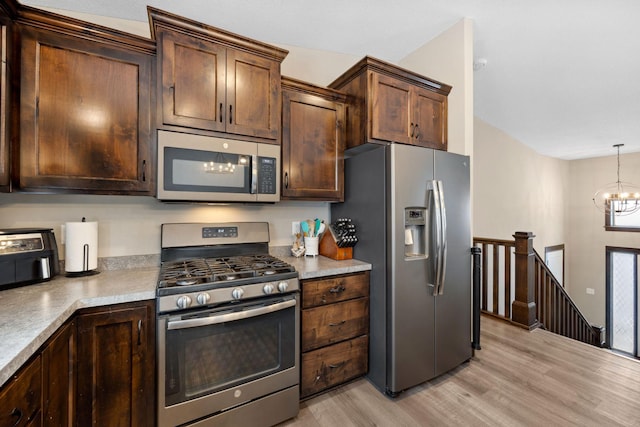 kitchen with dark brown cabinetry, an inviting chandelier, hanging light fixtures, stainless steel appliances, and light hardwood / wood-style floors