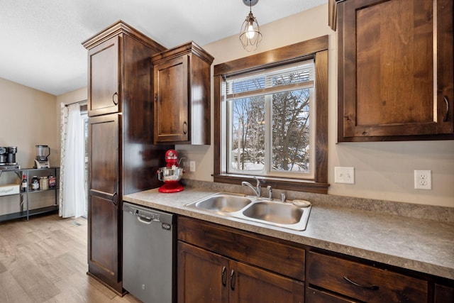 kitchen with pendant lighting, sink, light hardwood / wood-style flooring, dark brown cabinetry, and stainless steel dishwasher