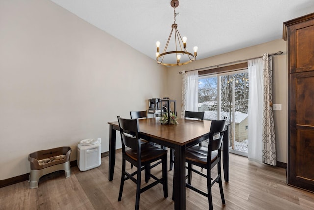 dining space with a chandelier and light hardwood / wood-style flooring