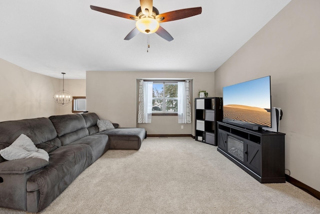 living room with vaulted ceiling, ceiling fan with notable chandelier, and light carpet