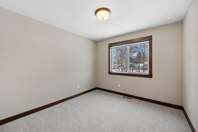 unfurnished room with carpet floors and a textured ceiling