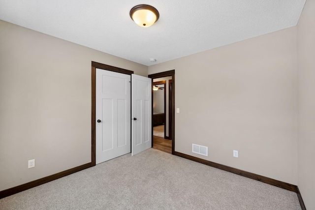 unfurnished bedroom featuring light carpet and a closet