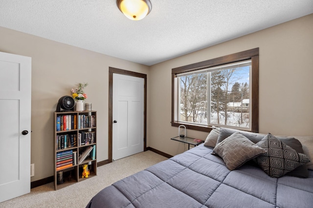 bedroom with light carpet and a textured ceiling