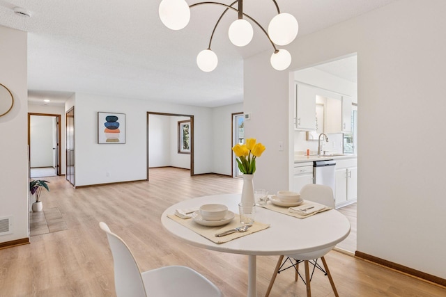 dining area with light wood-type flooring, baseboards, and visible vents