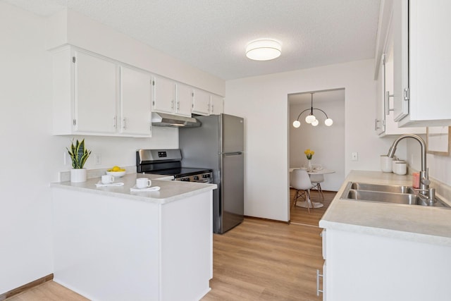 kitchen with under cabinet range hood, white cabinets, light wood finished floors, and a sink